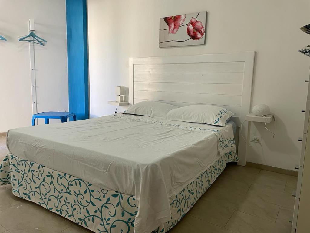 um quarto com uma cama grande e uma cabeceira branca em Appartamento Ivana em Favignana