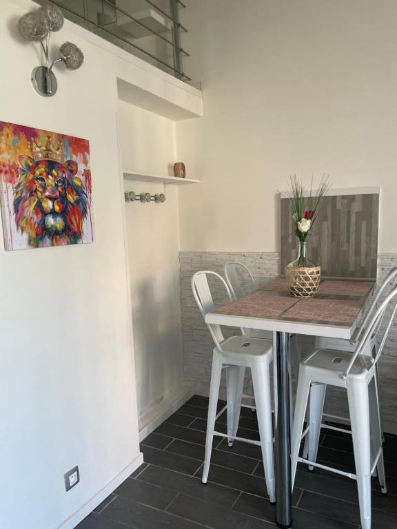 a dining room with a table and white chairs at Appartement de la Gabelle in Cap d'Agde