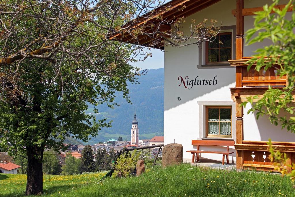 a building with a bench and a view of a city at Niglutsch Apartement Puflatsch in Castelrotto