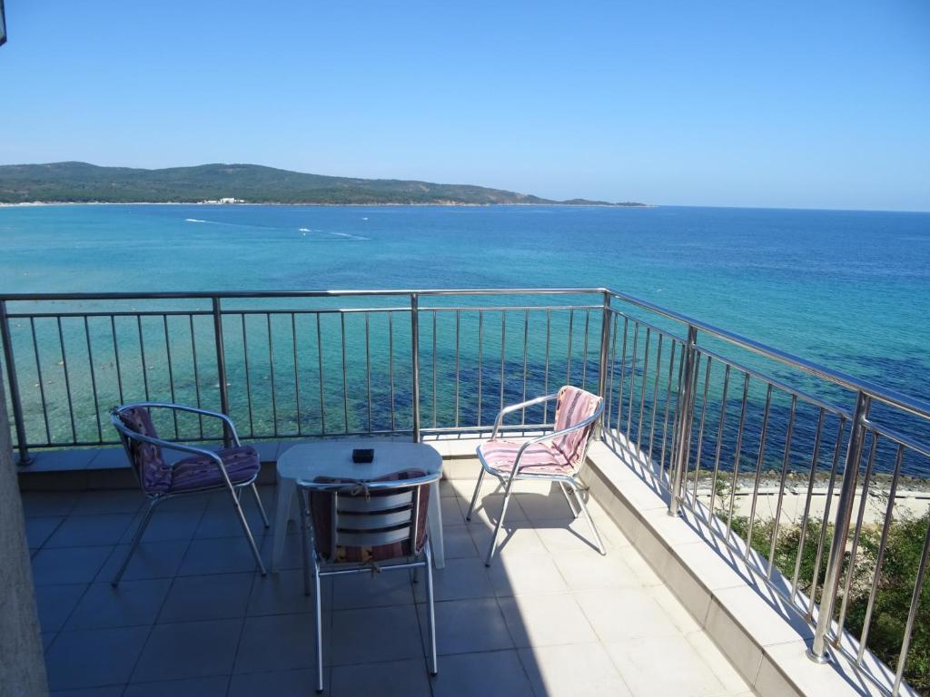 a balcony with chairs and a table and the ocean at Dobrevi Guest House in Primorsko
