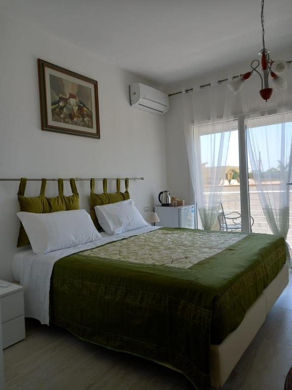 a bedroom with a large bed and a window at Villa Serendipity Terrasini in Terrasini