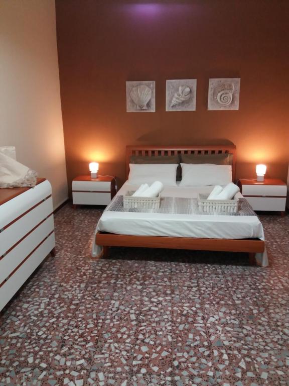 a bedroom with a large bed and two night stands at Casa Narciso tra mare e canyon ad Avola in Avola