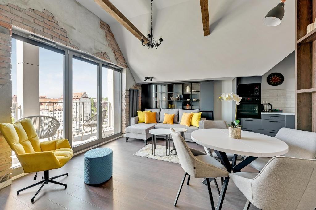 a living room with a white table and yellow chairs at Grano Residence - Pool, Sauna, SPA & Parking by Downtown Apartments in Gdańsk