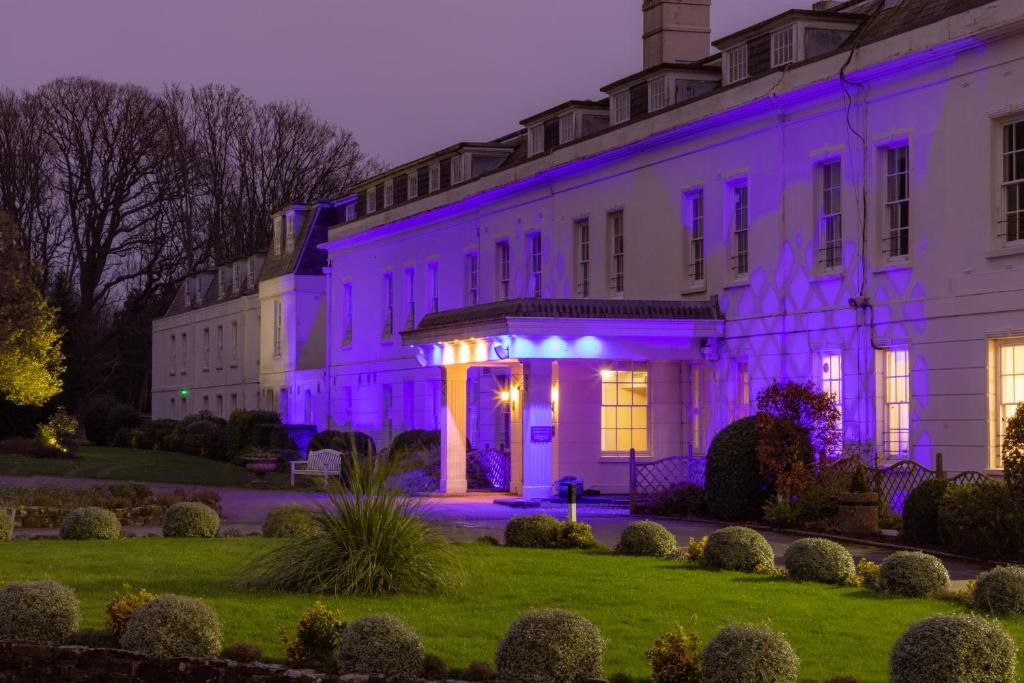 a white building with purple lights on it at Avisford Park Hotel in Arundel