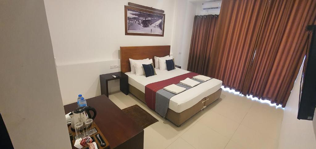 a bedroom with a bed and a table in a room at Hotel Kandyan View ''Free pickup from Kandy city'' in Kandy
