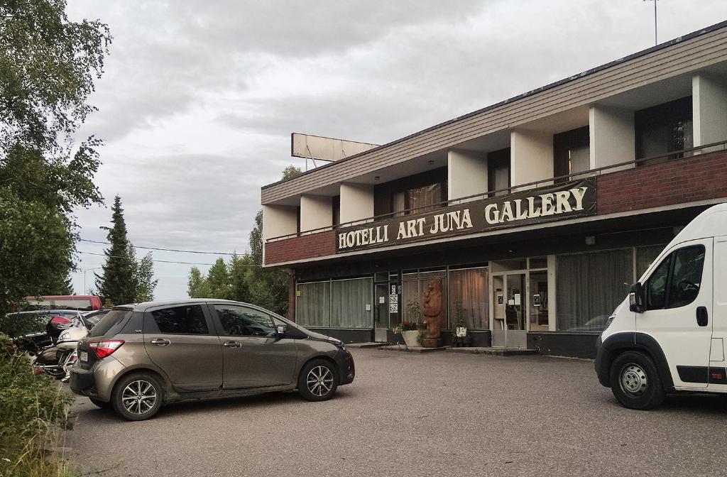 dwa samochody zaparkowane na parkingu przed budynkiem w obiekcie ART Hotel JUNA w mieście Imatra