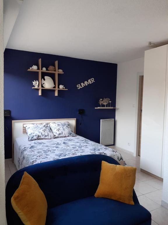 a bedroom with a bed with a blue wall at L'Escale Marine : Centre ville/ Plage in Bandol