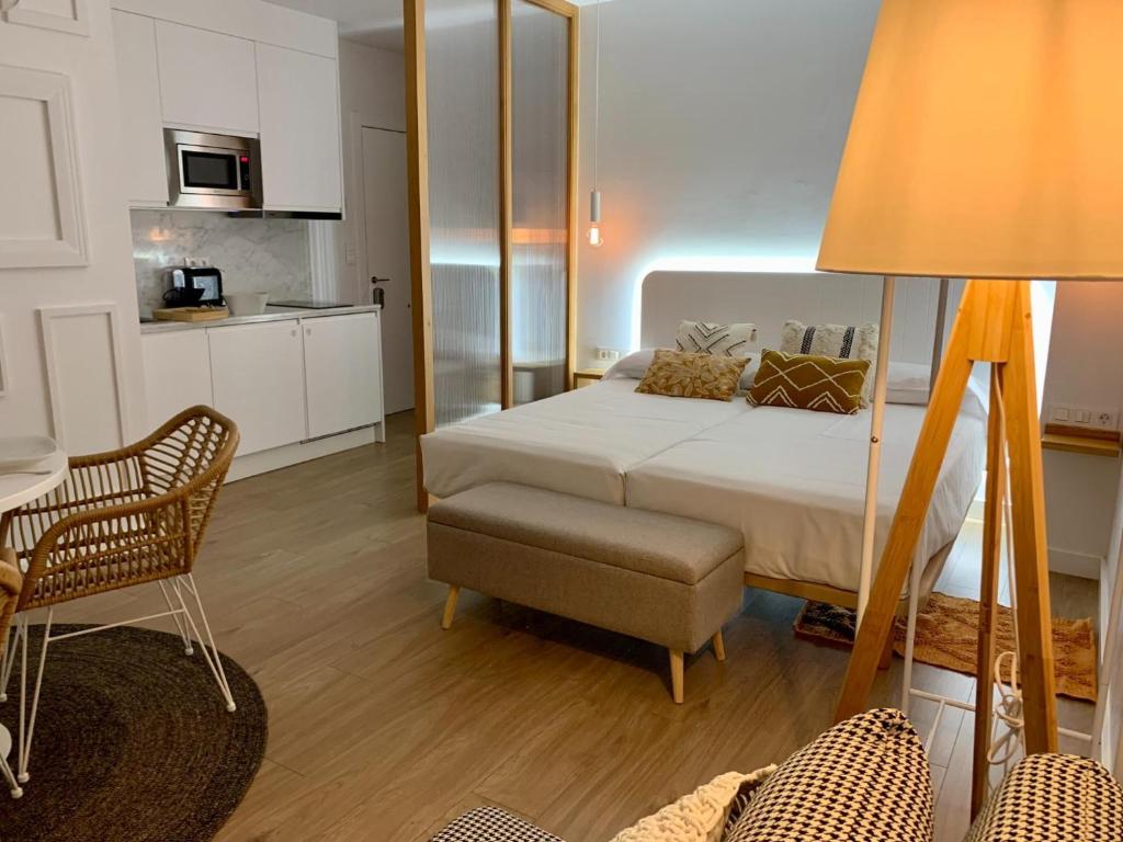 ein Schlafzimmer mit einem Bett und einem Tisch sowie eine Küche in der Unterkunft Apartamentos Succo in Plasencia