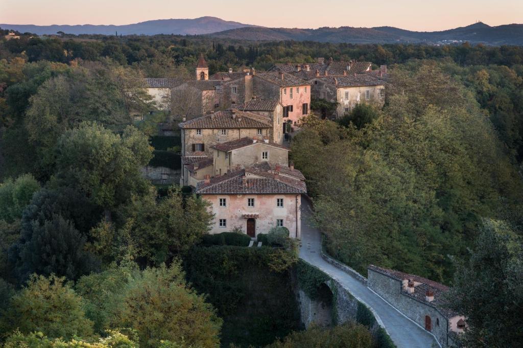 wioska na wzgórzu z rzeką przed nią w obiekcie Il Borro Relais & Châteaux w mieście San Giustino Valdarno