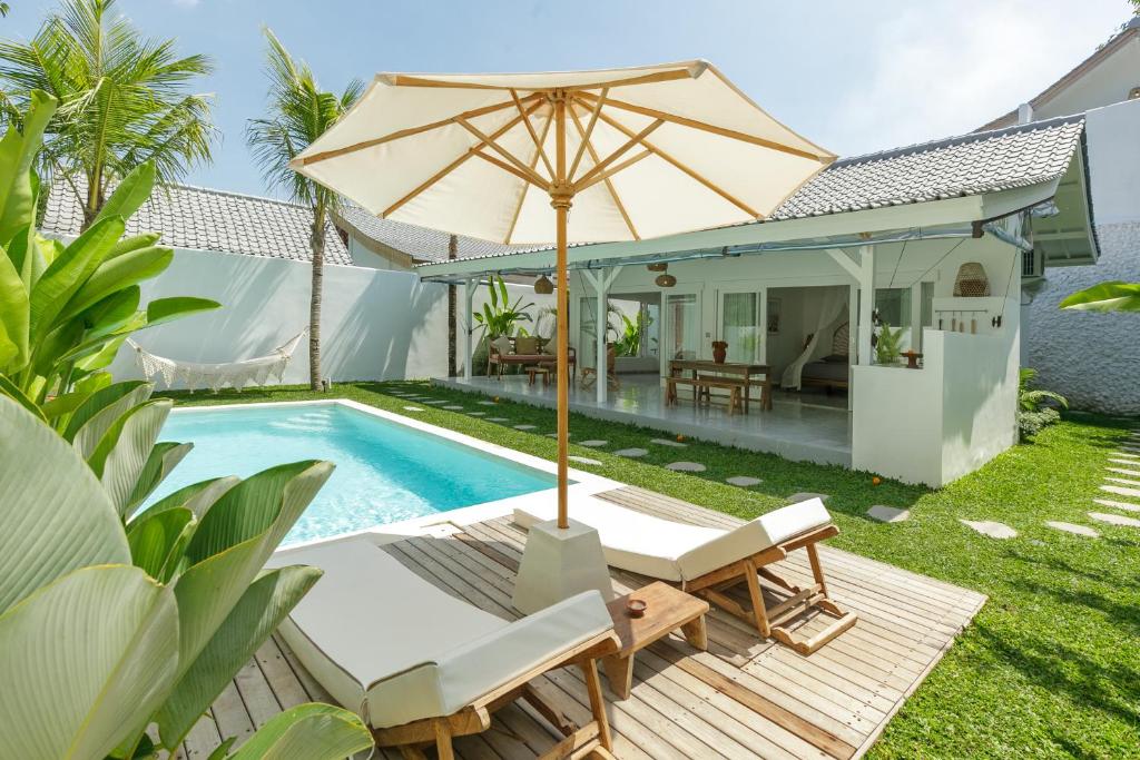 a patio with an umbrella and a swimming pool at The Bingin Beach Villas' Private Villas in Uluwatu