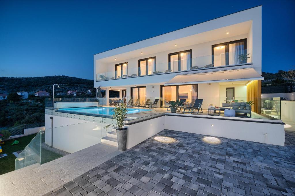 une grande maison blanche avec une piscine dans l'établissement Villa Larissa, à Dolac