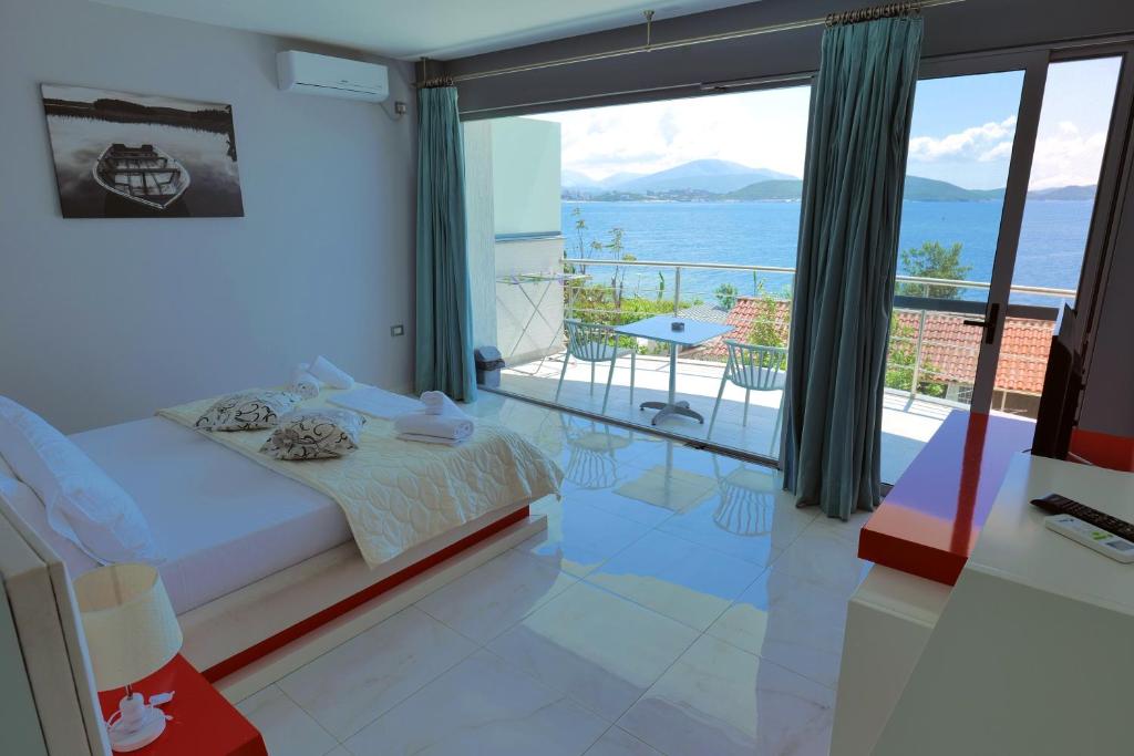 a bedroom with a bed and a view of the ocean at Oceanic Overview Suites in Sarandë