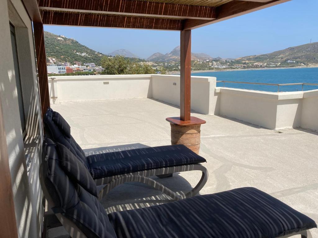 a porch with two chairs and a view of the water at Lilian Loft Sea View - Adults Only in Plakias