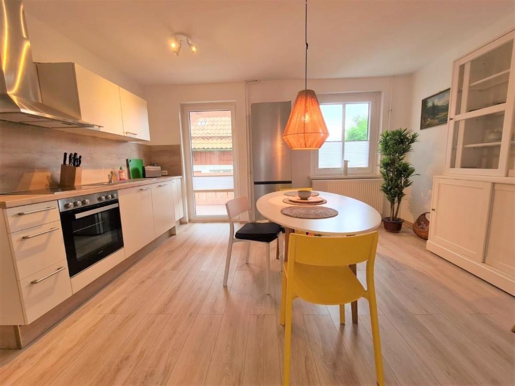 eine Küche mit einem Tisch und gelben Stühlen in der Unterkunft Appartment Friedrich in Bad Sachsa