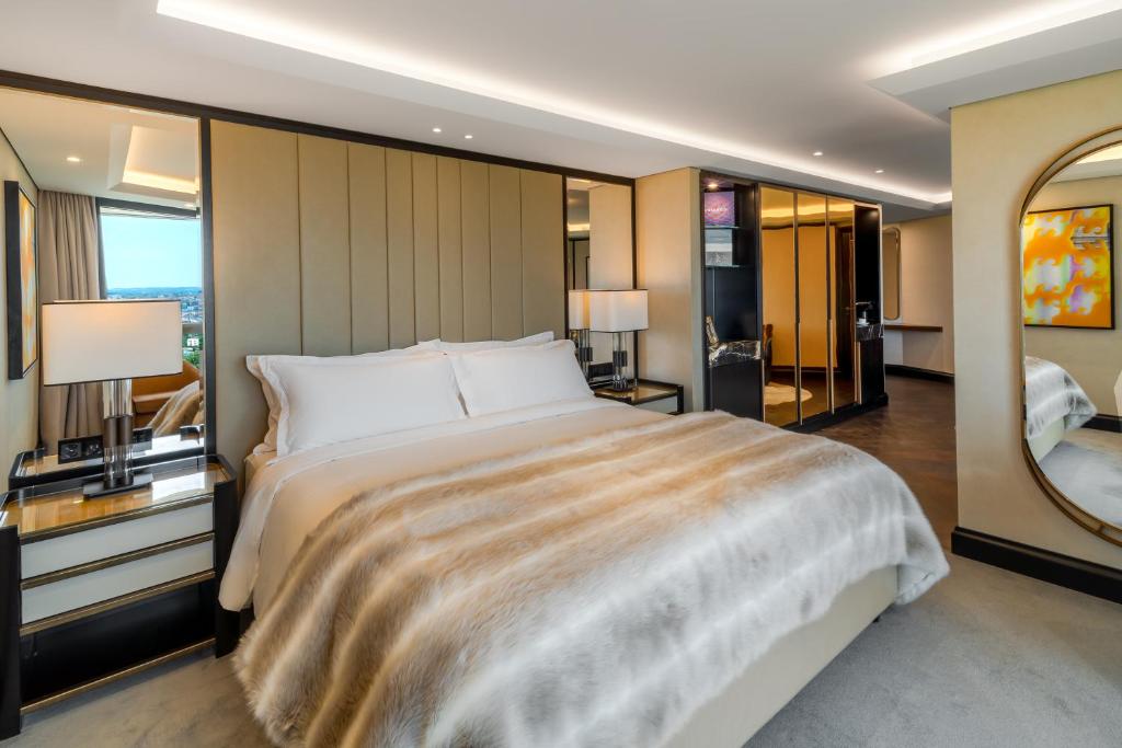 a bedroom with a large bed and a mirror at FIVE Zurich - Luxury City Resort in Zürich
