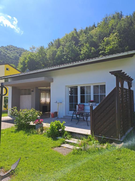 una pequeña casa blanca con una valla de madera en Haus beim Wasser im grünen in sehr ruhiger Lage!!, en Willersbach