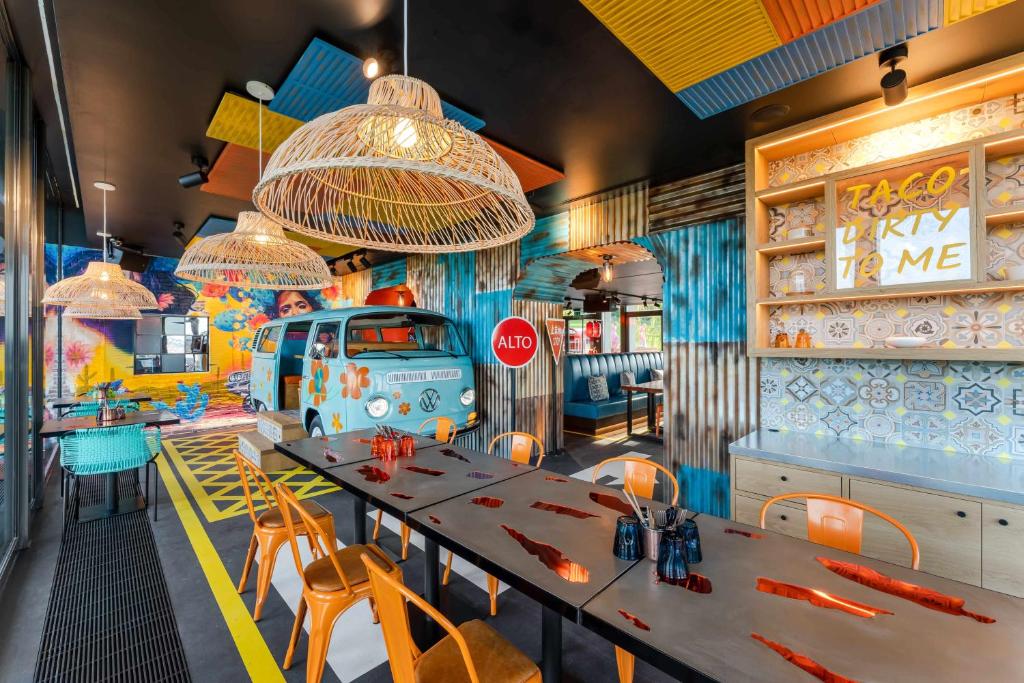 a restaurant with tables and chairs and a van painted on the wall at FIVE Zurich - Luxury City Resort in Zürich