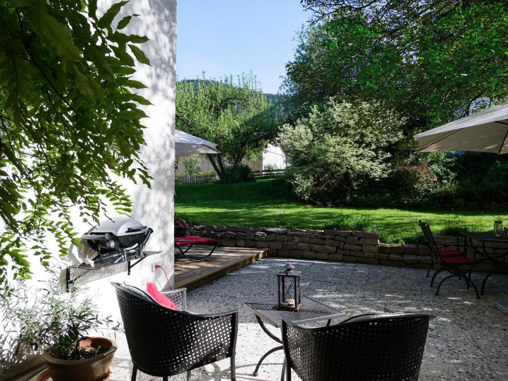 un patio con sillas y una parrilla en Helles 2-Zimmer-Apartment in Ostin am Tegernsee, en Gmund am Tegernsee