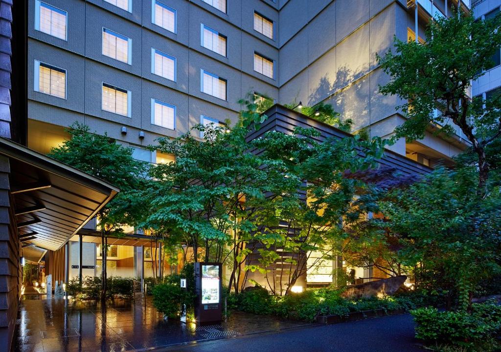 un gran edificio con árboles delante de él en Hotel Niwa Tokyo, en Tokio