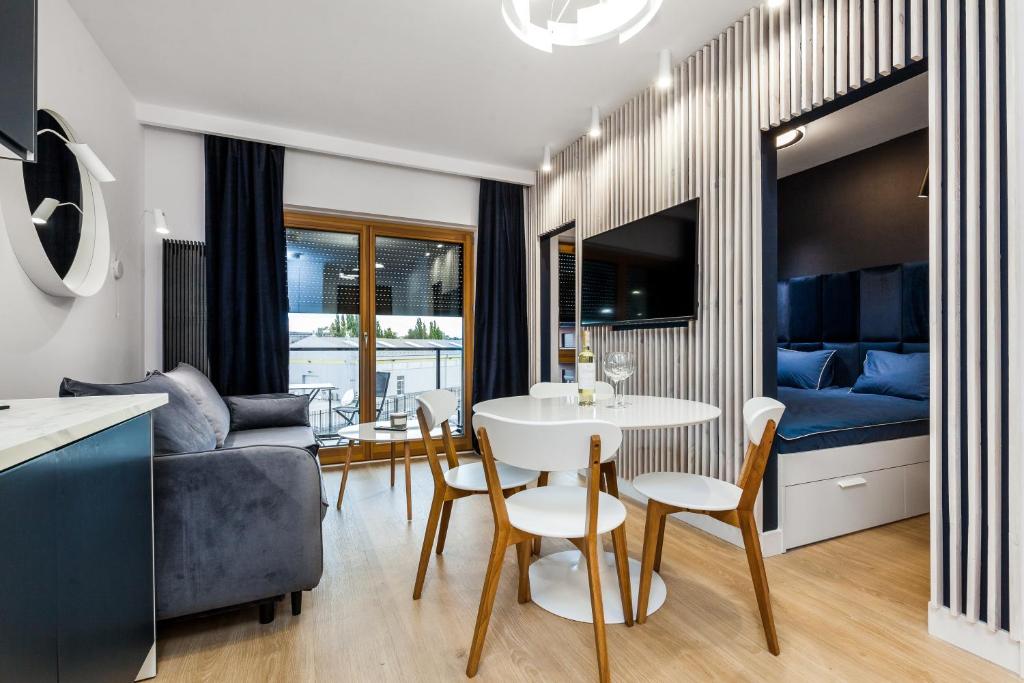 a kitchen and living room with a white table and chairs at Uroczy Apartament w Centrum Starego Miasta in Gdańsk
