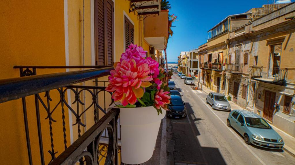une fleur en pot sur un balcon dans une rue de la ville dans l'établissement Le Case del Porticciolo, à Isola delle Femmine