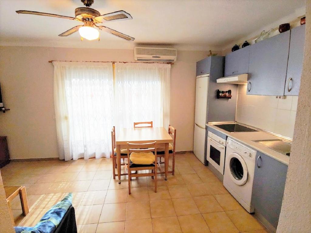 a kitchen with a table and a table and a washing machine at Miramar Serveis - Pins II in Cambrils