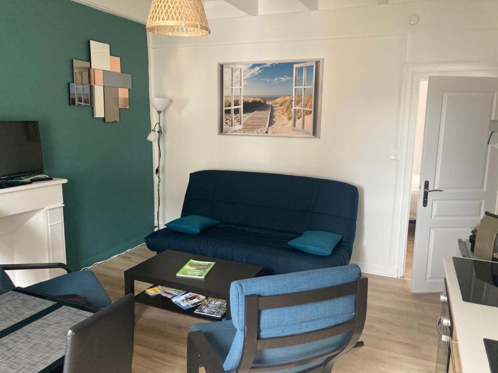 a living room with a blue couch and a table at Les locations d'Argol in Argol