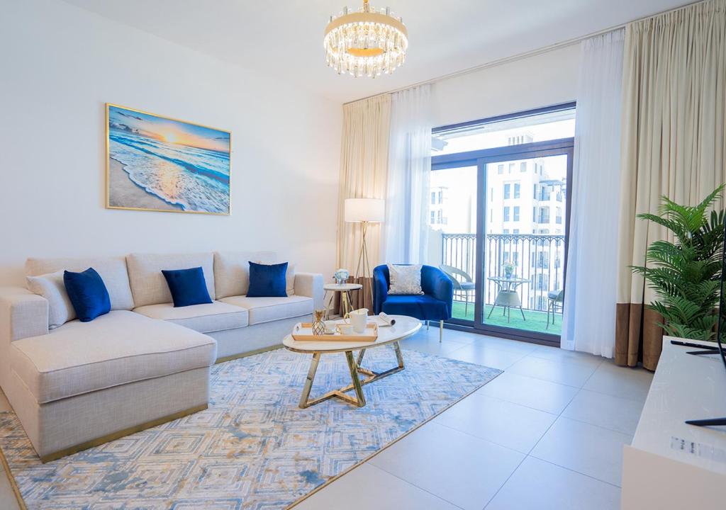 ein Wohnzimmer mit einem Sofa und einem Tisch in der Unterkunft Nasma Luxury Stays - Fancy Apartment With Balcony Close To MJL's Souk in Dubai
