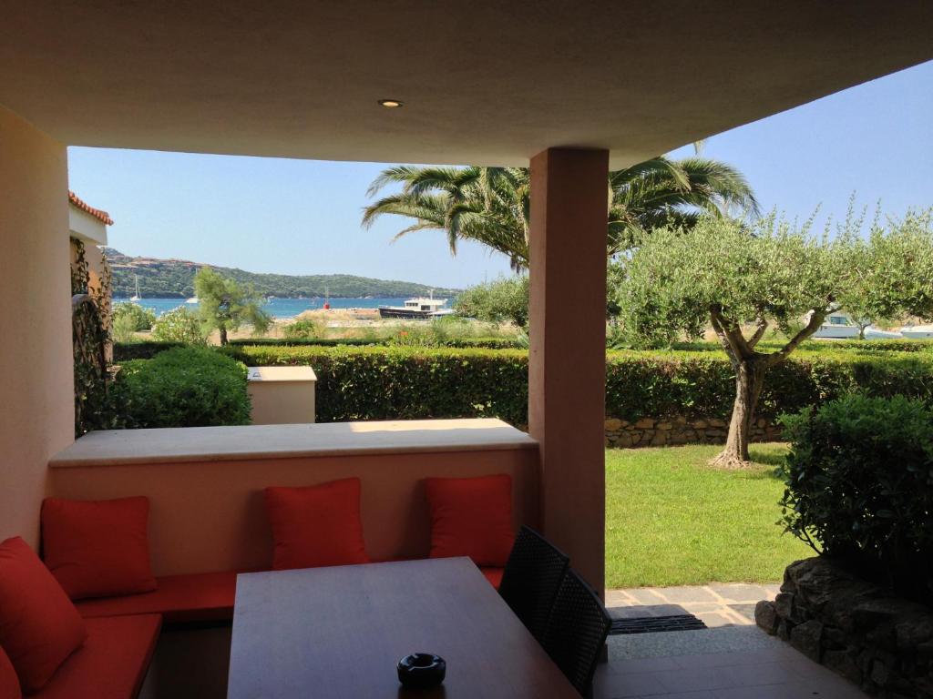 a patio with a table and a view of the ocean at Sardegna Beach Cala Reale in Santa Marinella