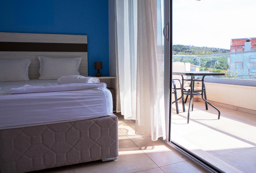 a bedroom with a bed and a balcony with a table at Vila Kalina Sutomore in Sutomore