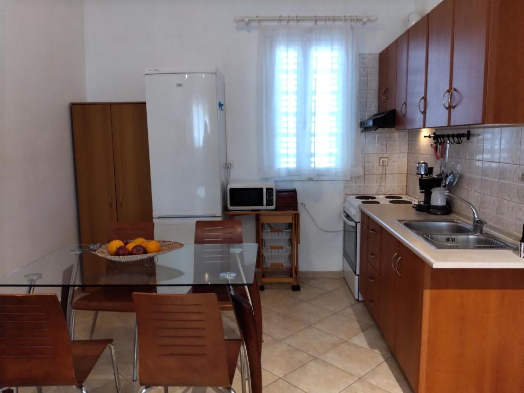 a kitchen with a table and a sink and a refrigerator at Comfy Alykes Apartment, Volos in Volos