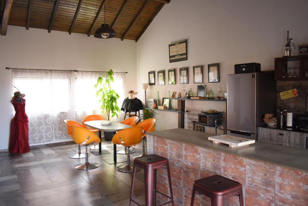 una cocina con mesa y algunas sillas naranjas en la casa gastounette, en Maiorca