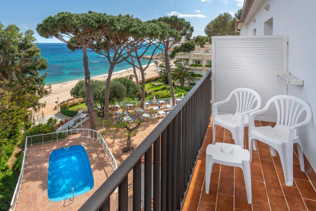 balcón con sillas y vistas a la playa en GHT Xaloc, en Platja d'Aro