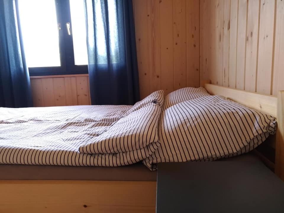 a bed sitting in a room with a window at Przystań Kajakowa Zakole in Buda Ruska
