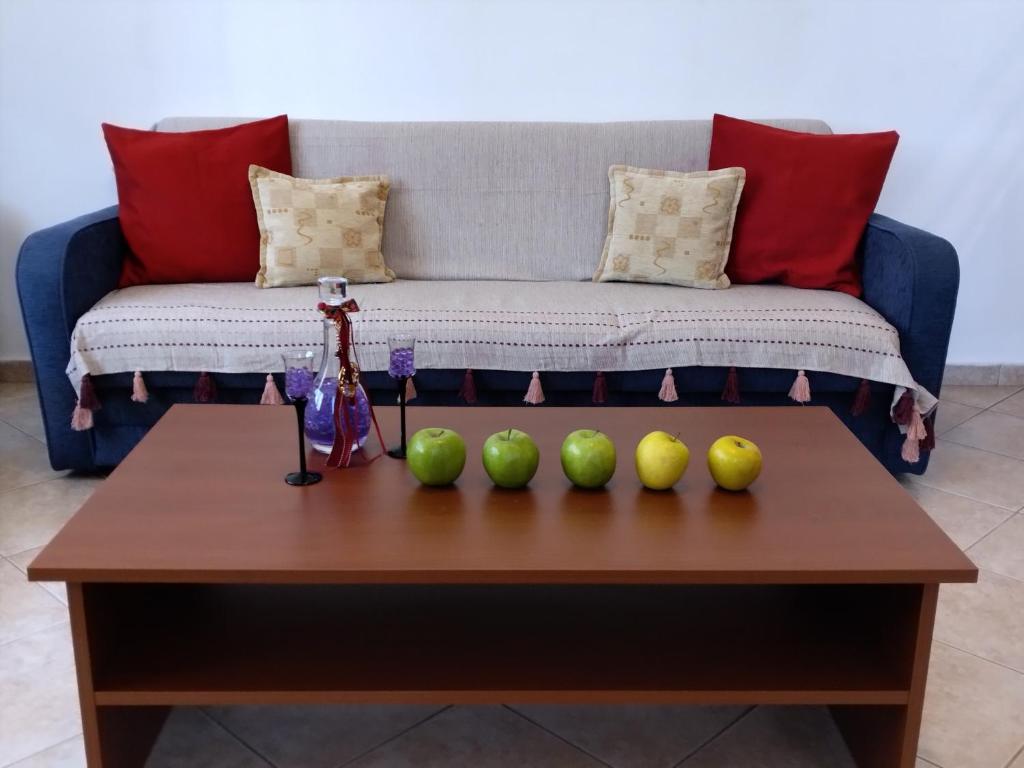 a coffee table with four green apples on it at Comfy Alykes Apartment, Volos in Volos