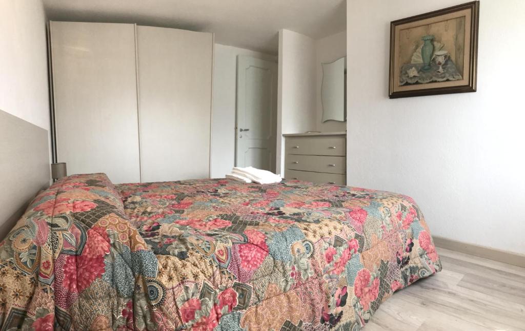 a bedroom with a bed with a colorful quilt at Sardegna Beach Cala Reale in Santa Marinella