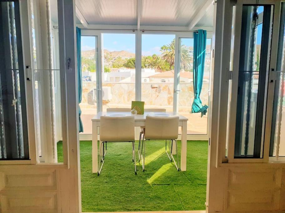 ein weißer Tisch und Stühle in einem Raum mit einem Fenster in der Unterkunft The perfect place to relax Bedroom with hot tub, beautiful tropical garden area. Bbq and big open spaces through all the house.It is located in a quiet place, but still 5 min away from the touristic Puerto Rico and walking distance from the beach in Mogán