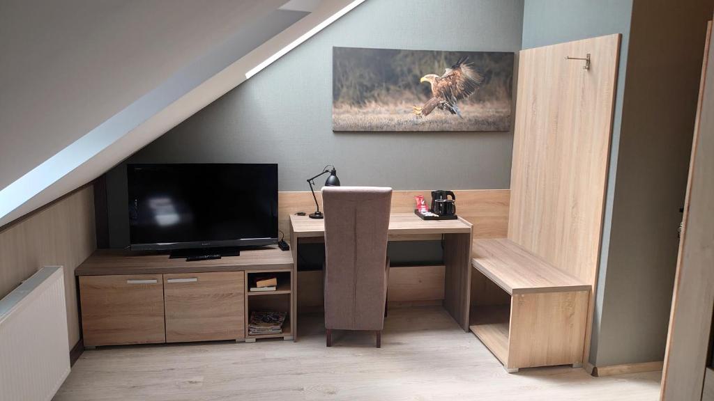 Zimmer mit einem Schreibtisch, einem TV und einer Treppe in der Unterkunft FitnessFun in Krzyż