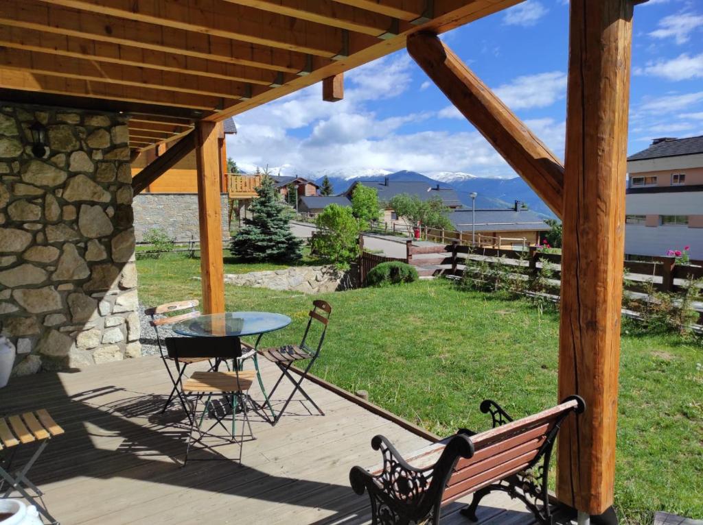 une terrasse en bois avec une table, une table et des chaises dans l'établissement Chalet Le Cambre d'Aze, à Font-Romeu