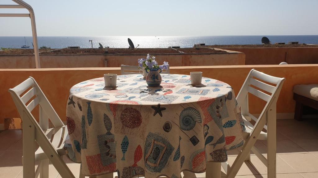 einen Tisch mit 2 Stühlen und einen Tisch mit einem Tischtuch in der Unterkunft STELLA BEACH HOUSE AT FREE BEACH RESIDENCE in Costa Rei