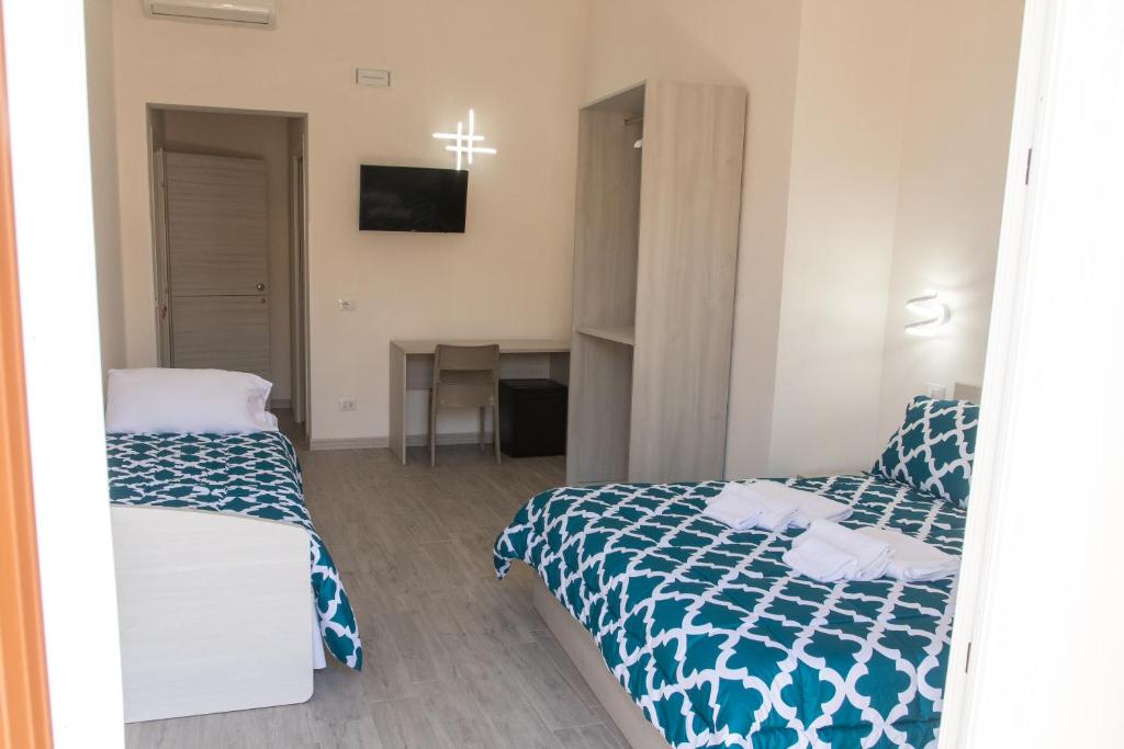 een hotelkamer met 2 bedden en een bureau bij La Farfalla in Favignana