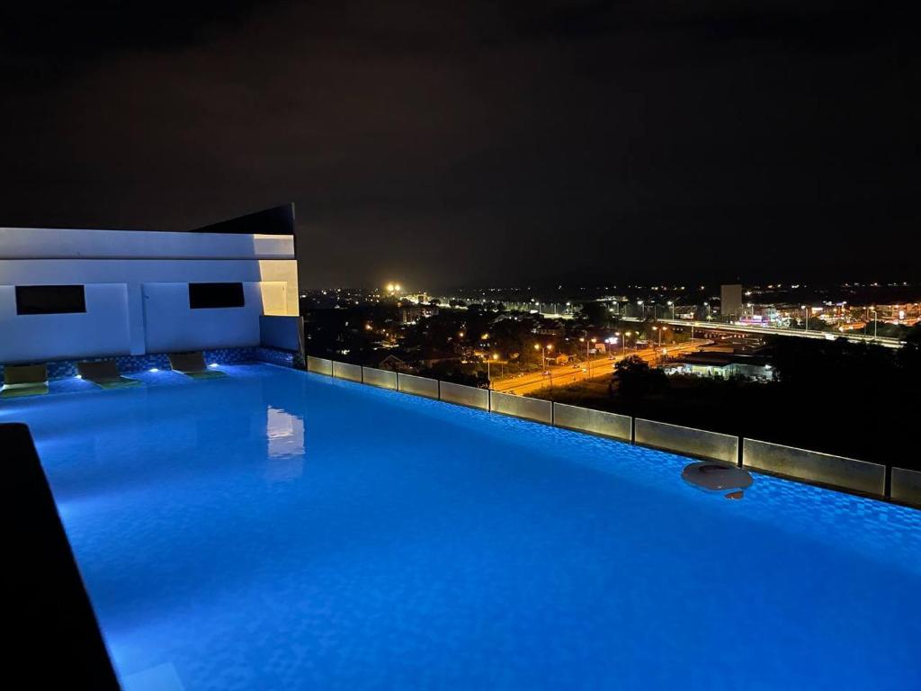 a swimming pool at night with a view of a city at SOFEA IMPERIO HOMESTAY @ ALOR SETAR in Alor Setar