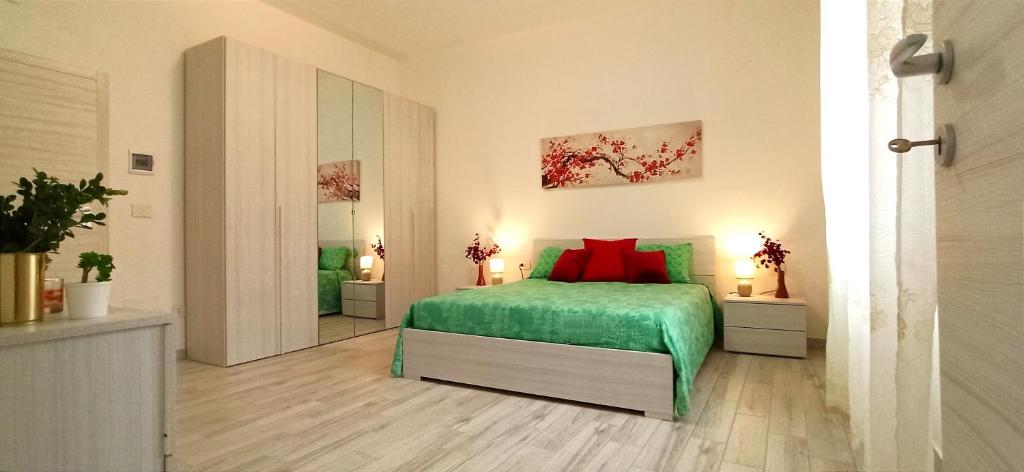 una camera da letto con letto verde e cuscini rossi di LA CASA DI FRANCESCO a Putifigari