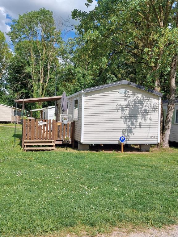 une remorque blanche assise dans une cour à côté d'une maison dans l'établissement Anne Marie vous accueilles dans son logement familiale pour 6 personnes 3 chambres confortable proche d Europa Park a BOOFZHEIM dans CAMPING 3 Etoiles, à Boofzheim