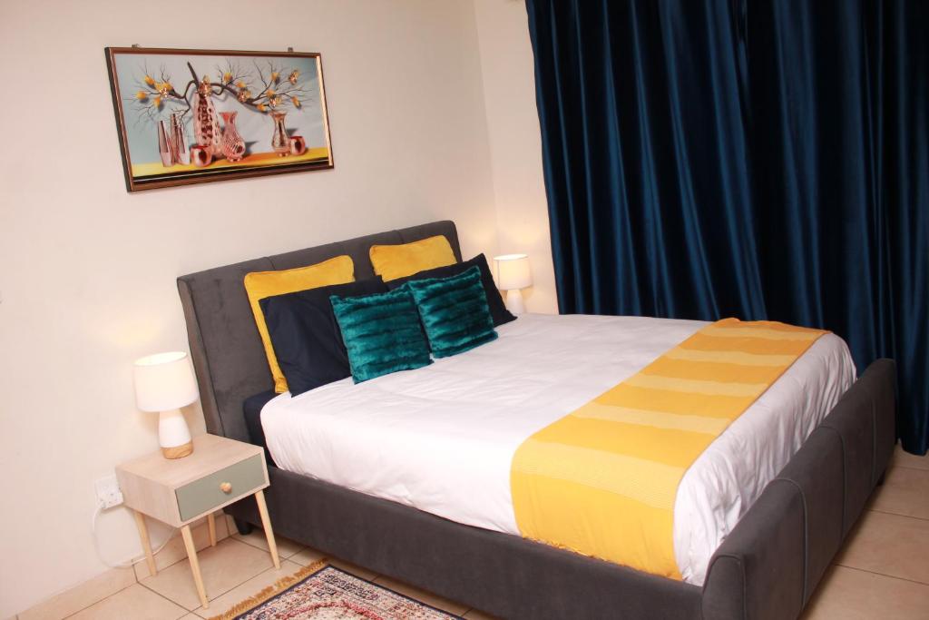 1 dormitorio con 1 cama grande con almohadas amarillas y azules en 43 Home self Catering with backup power, en Witbank