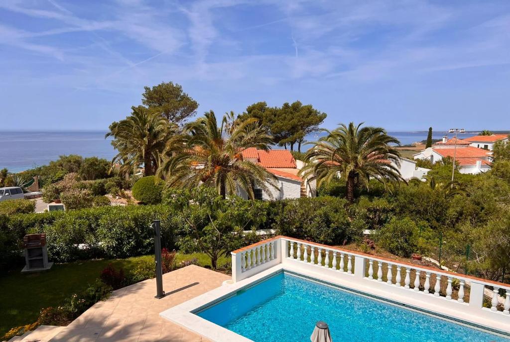 a swimming pool in front of a house with a balcony at Villa Joanna in Son Bou