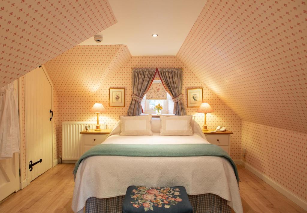 Un dormitorio con una cama grande y una ventana en Balnagown Estates Gardener's Cottage, en Kildary
