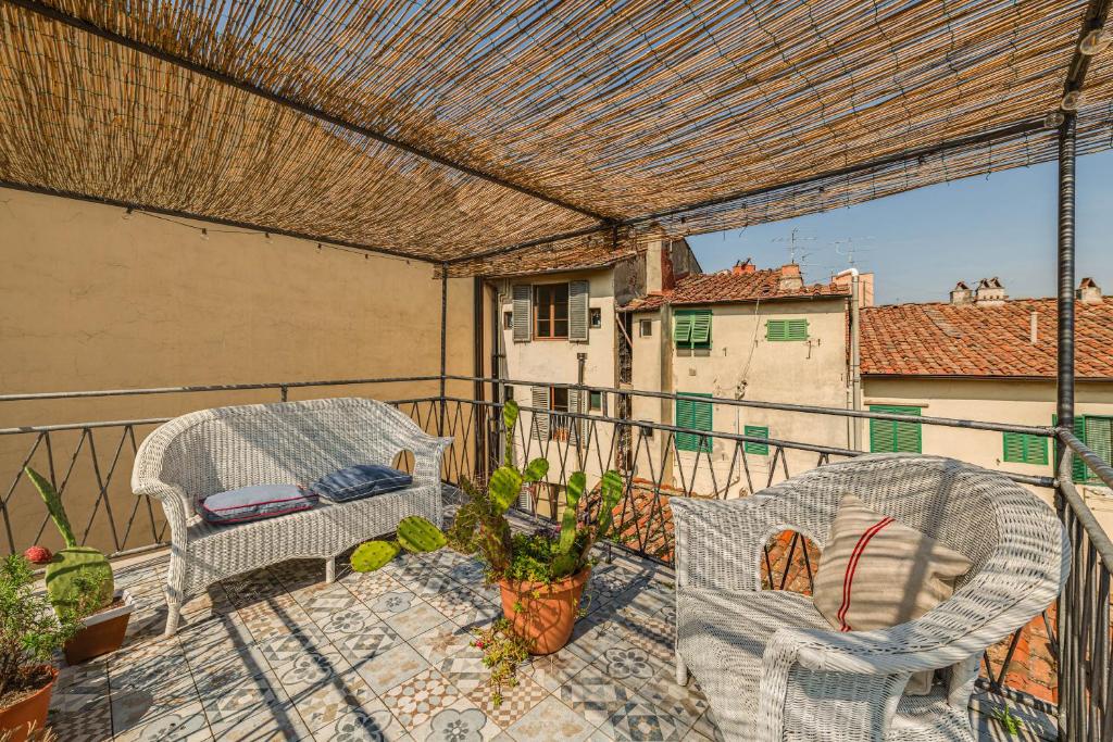 einen Balkon mit 2 Stühlen und einer Pergola in der Unterkunft Apartments Florence - Sprone Terrace in Florenz