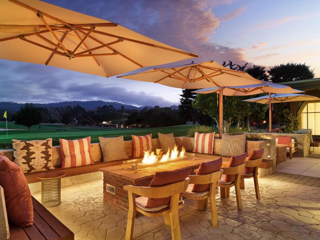 a patio with a table and a couch and umbrellas at Hyatt Regency Monterey Hotel and Spa in Monterey