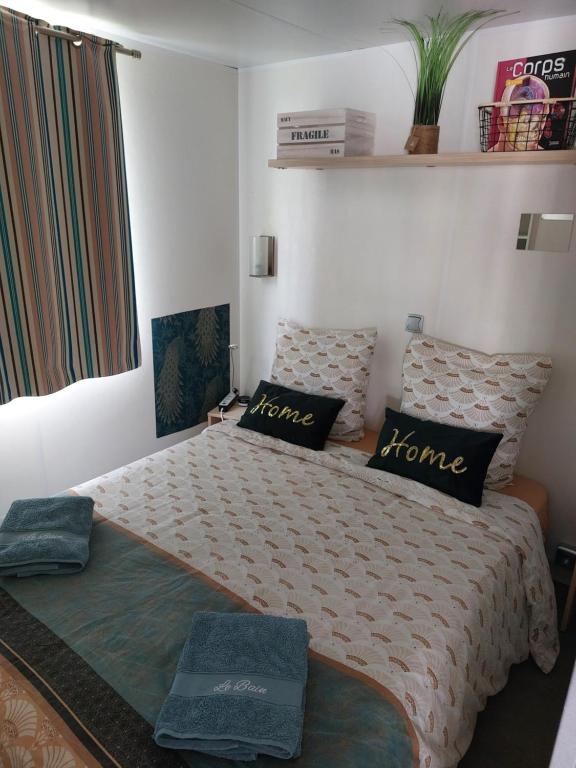 une chambre avec un grand lit avec des oreillers dessus dans l'établissement Anne Marie vous accueilles dans son logement familiale pour 6 personnes 3 chambres confortable proche d Europa Park a BOOFZHEIM dans CAMPING 3 Etoiles, à Boofzheim 35 autres photos